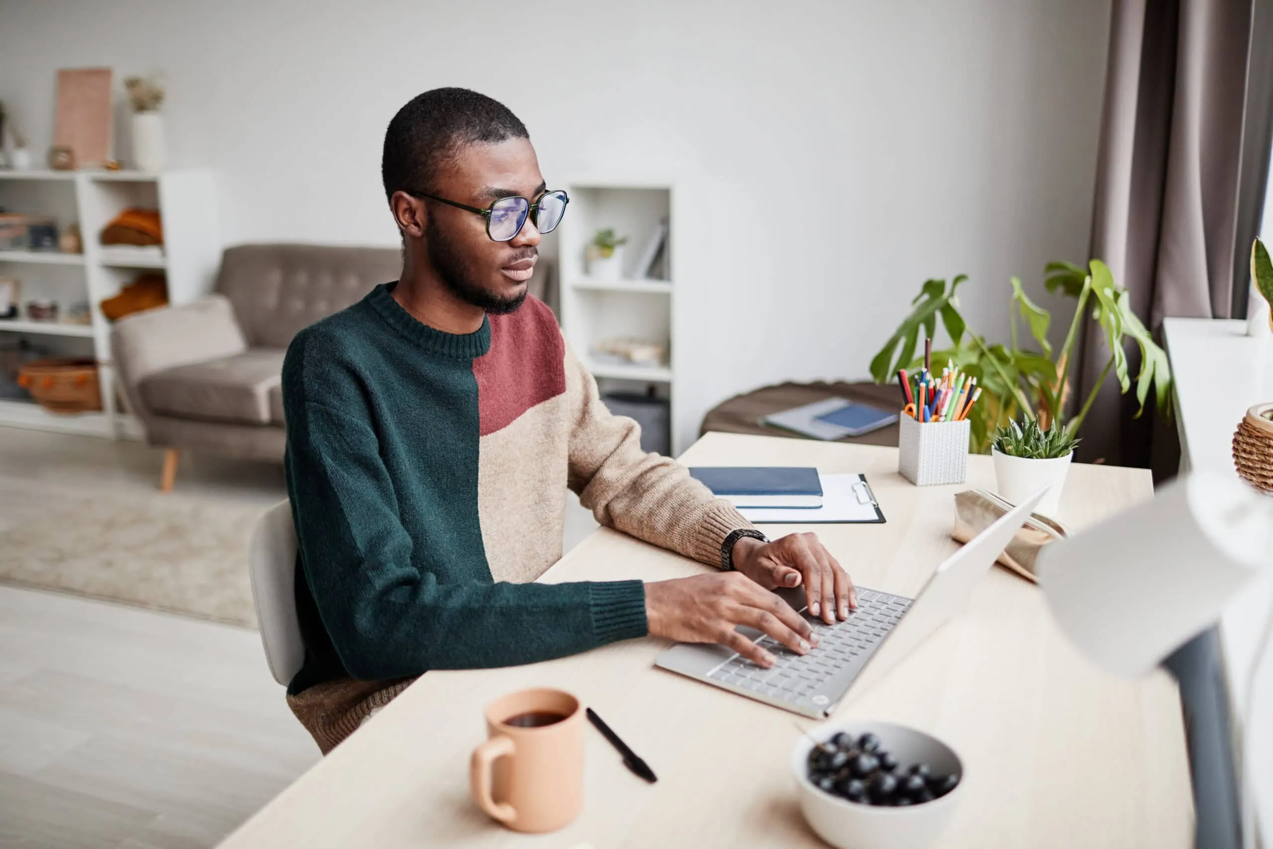 Young Man Working on a Laptop | i3solutions Young man working on a laptop in a modern home office setting.