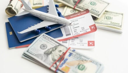 Model airplane, passport, and money on white background for travel planning.