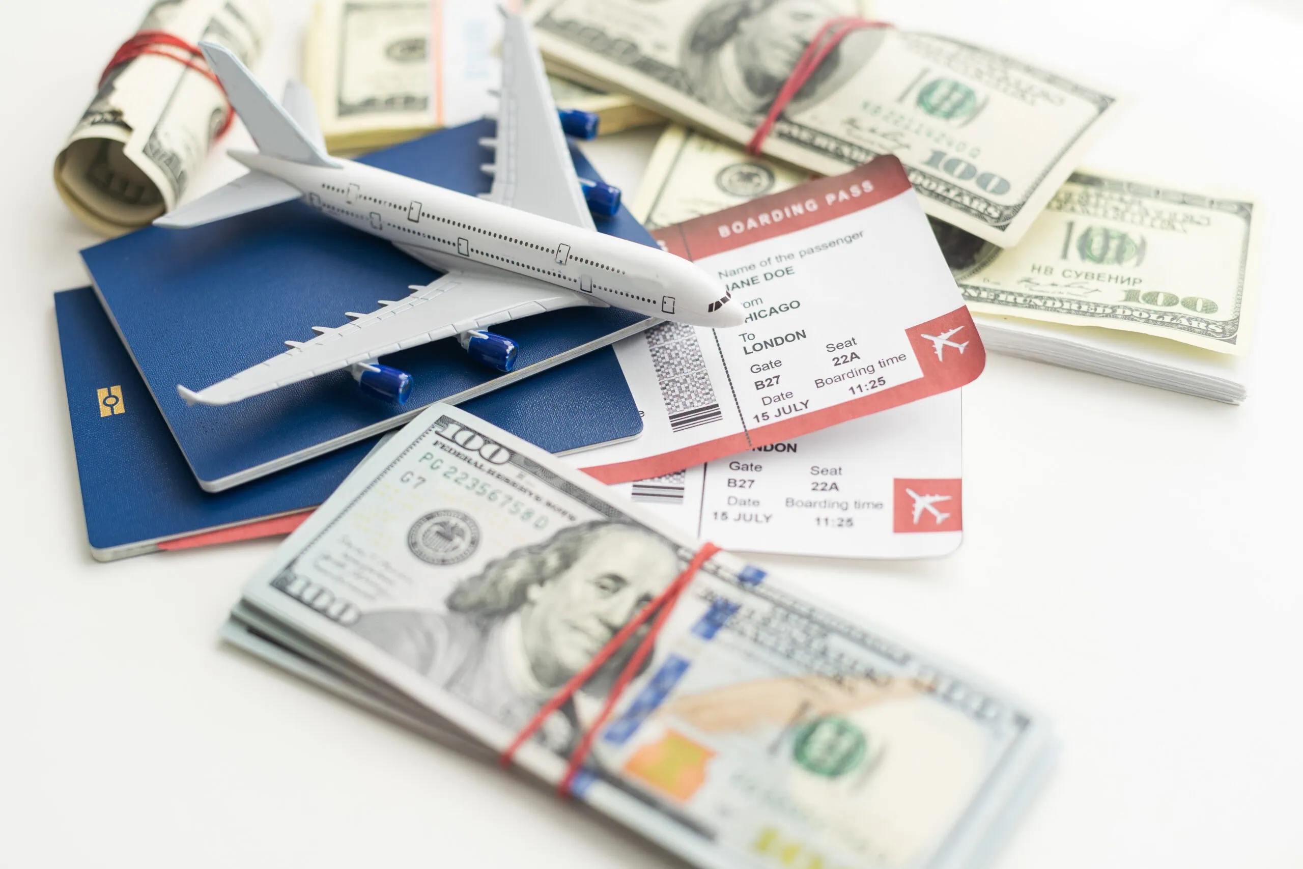 Model Airplane, Passport, and Money on White | i3solutions Model airplane, passport, and money on white background for travel planning.