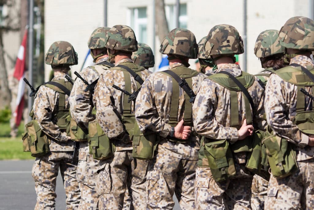 Military soldiers in camouflage uniforms standing in formation outdoors.